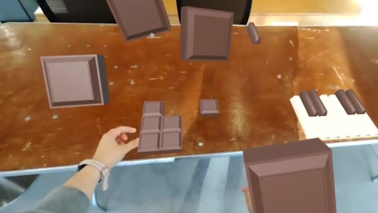 Pinching a chocolate instrument to separate it from the set and move it in AR space