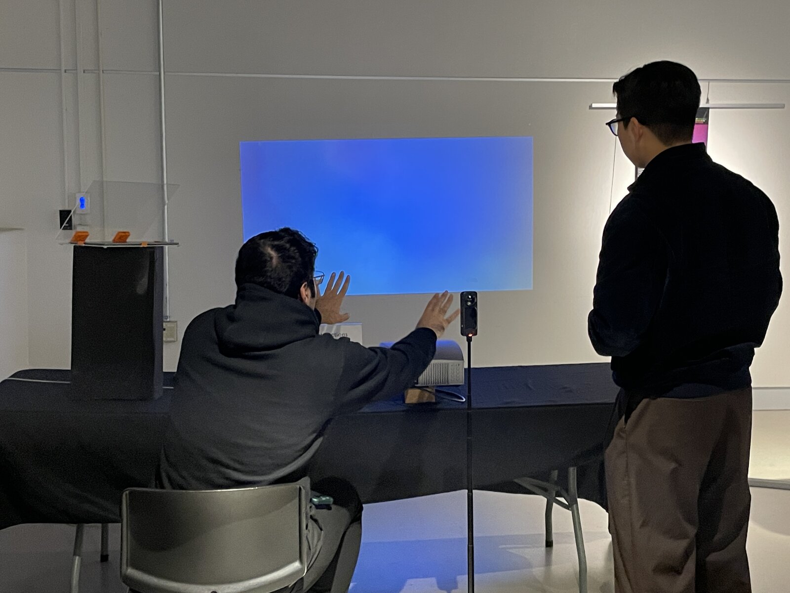 A visitor interacting with the projected field, hand raised